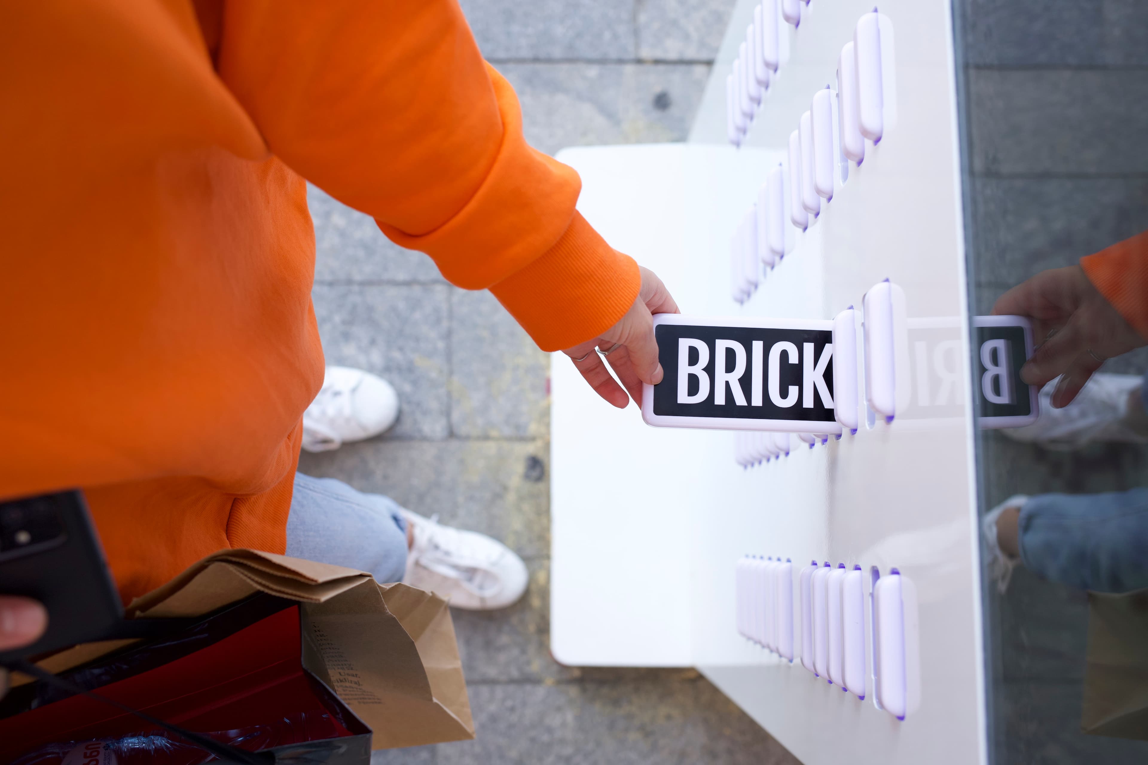 Eine Hand, die eine Brick-Powerbank aus einer Station holt